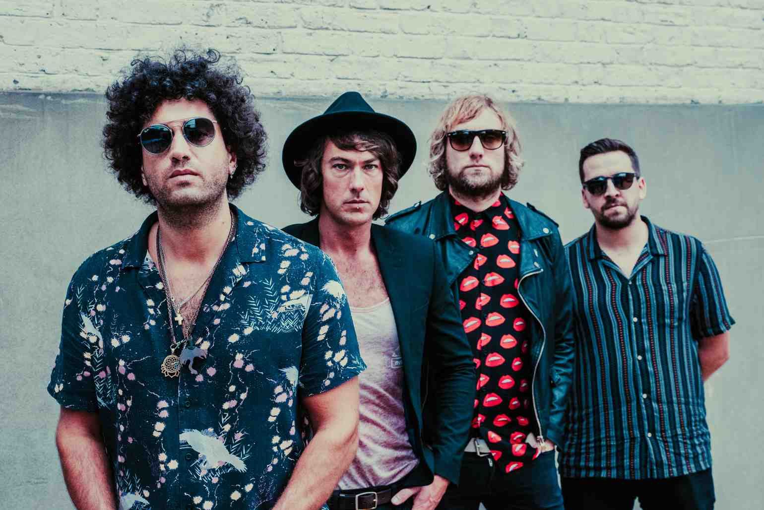 The four members of The West Coast Heroes in patterned shirts and sunglasses